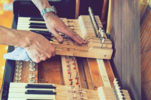 setting up an old piano. the master repairs an old piano. deep cleaning the piano. hands of professional worker repairing and tuning an old piano. toned.